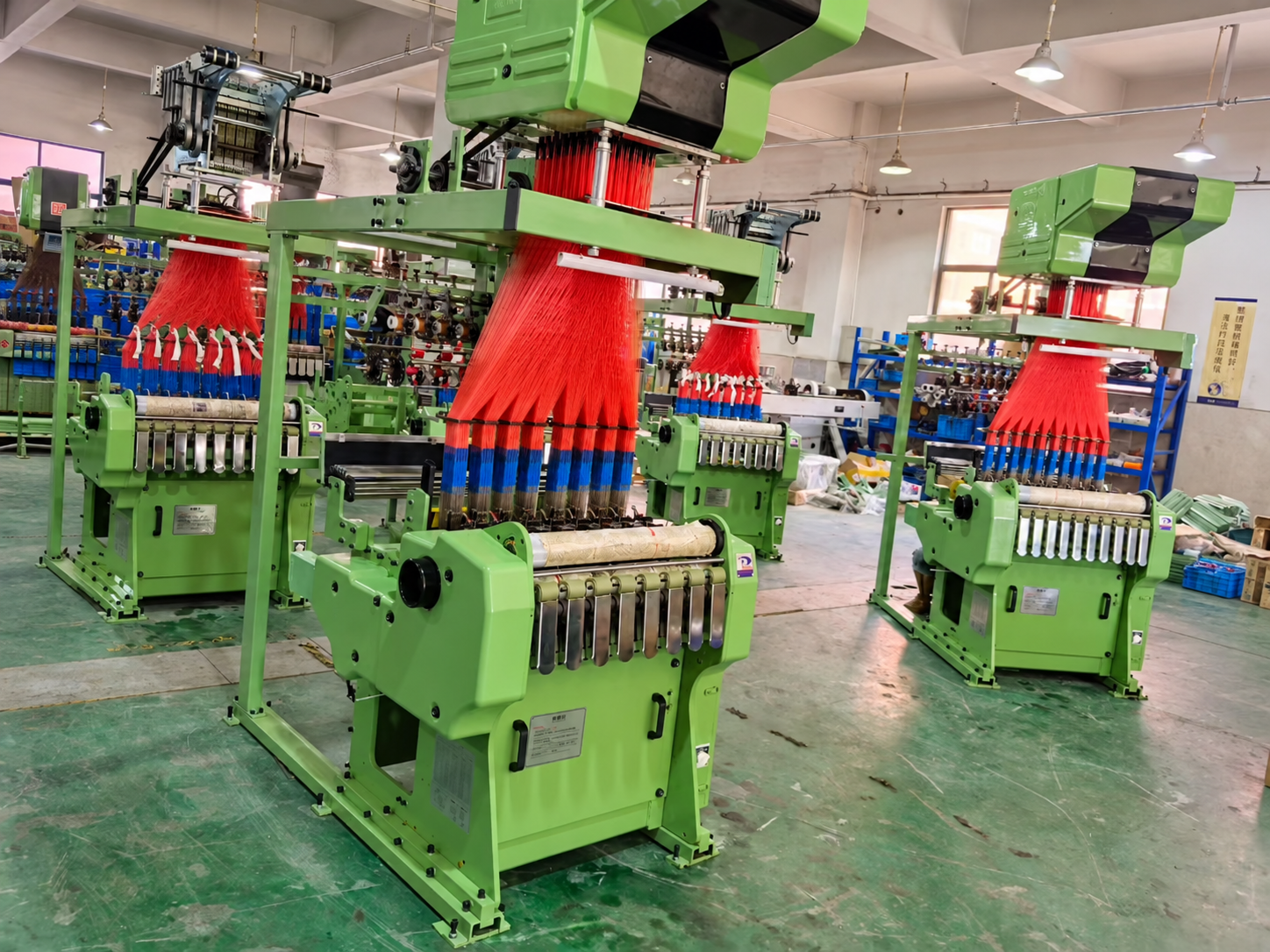 Jinghui webbing machines operating with red and blue yarn in the workshop