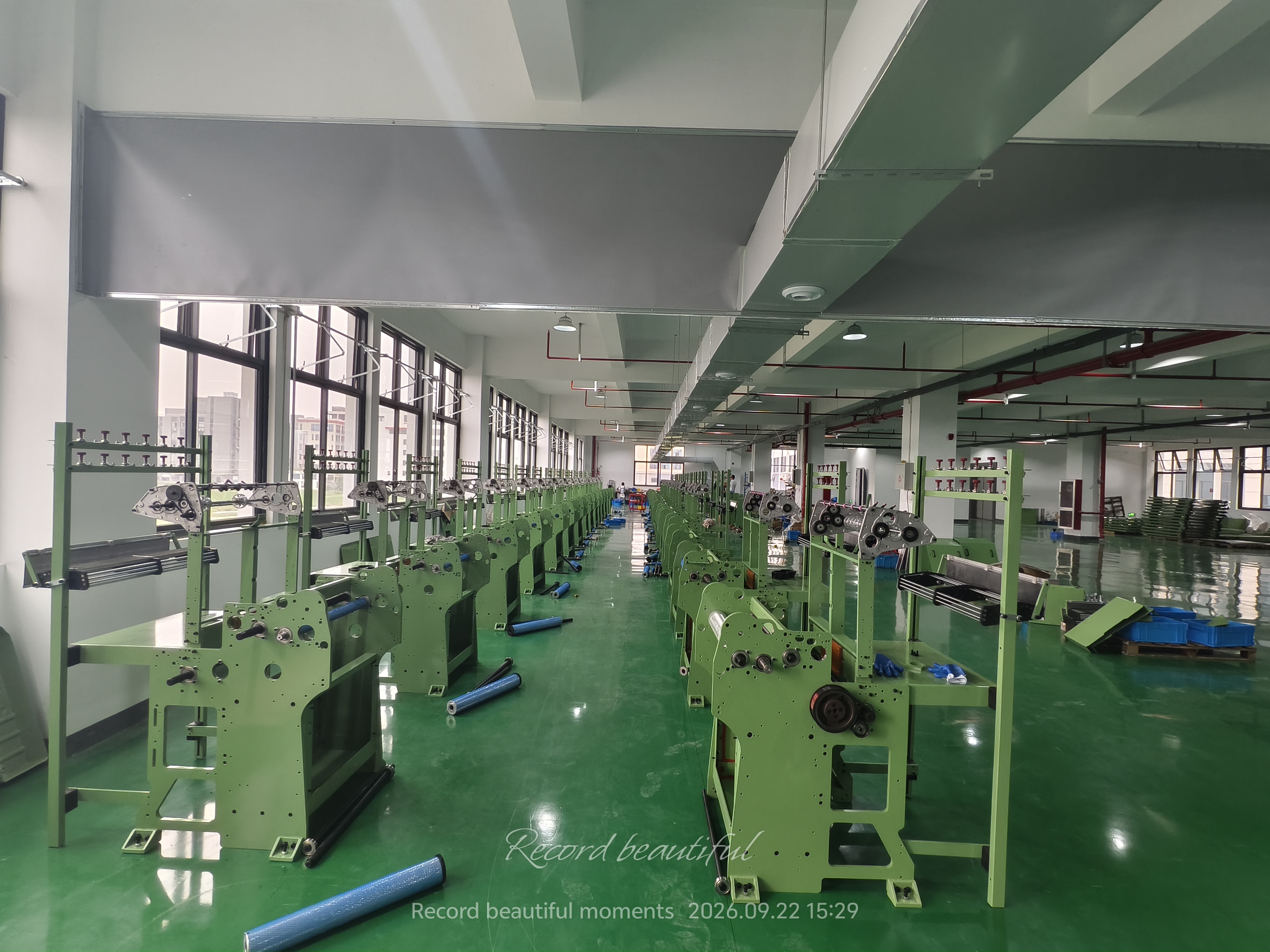 Rows of webbing machine frames in the Jinghui production hall